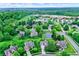 Aerial view of a residential neighborhood with mature trees and a pond at 10906 Camden Ct, Fishers, IN 46038