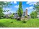 Landscaped backyard featuring lush green grass, mature trees, and a garden at 10906 Camden Ct, Fishers, IN 46038