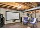Finished basement with movie screen, speakers, exercise equipment, and seating for entertainment and fitness at 10906 Camden Ct, Fishers, IN 46038