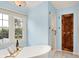 Freestanding tub in a bright bathroom with an accent door at 10906 Camden Ct, Fishers, IN 46038