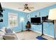Bright bedroom with a large window, comfy couch, and setup with TV and standing desk at 10906 Camden Ct, Fishers, IN 46038