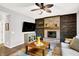 Warm living room features a brick fireplace, wood accent wall, stylish decor, and comfortable seating at 10906 Camden Ct, Fishers, IN 46038