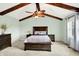 Comfortable main bedroom features a wooden beam ceiling, neutral paint, and lots of natural light at 10906 Camden Ct, Fishers, IN 46038