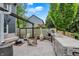 Outdoor stone kitchen and entertainment area with grill, fire pit, seating and mature trees at 10906 Camden Ct, Fishers, IN 46038