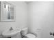 Cozy powder room features a pedestal sink, toilet, and framed mirror at 1111 Cavendish Dr, Carmel, IN 46032