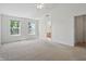 Bright bedroom with neutral carpet, large windows, ceiling fan, and access to a private bathroom and walk-in closet at 1111 Cavendish Dr, Carmel, IN 46032