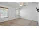 Spacious bedroom with neutral carpet, a ceiling fan, a wall-mounted TV, and bright, sunny windows with backyard views at 1111 Cavendish Dr, Carmel, IN 46032
