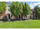 Well-maintained townhomes feature brick facade, manicured lawns, and mature shade trees at 1111 Cavendish Dr, Carmel, IN 46032