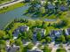 Aerial view of homes in a neighborhood surrounding a small lake and pond, showcasing community and landscaping at 11727 Wedgeport Ln, Fishers, IN 46037