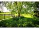 Scenic backyard featuring a tree, flowers and a fence at 11727 Wedgeport Ln, Fishers, IN 46037