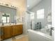 Bright bathroom featuring a double vanity, soaking tub, and tiled floors at 11727 Wedgeport Ln, Fishers, IN 46037