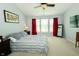 Bedroom boasts a window with red curtains, neutral carpet, and a ceiling fan at 11727 Wedgeport Ln, Fishers, IN 46037