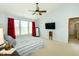 Comfortable bedroom featuring a ceiling fan, window, television, and red curtains at 11727 Wedgeport Ln, Fishers, IN 46037