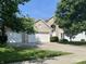 Charming home boasts a three-car garage, brick facade, and well-maintained landscaping, all under a beautiful blue sky at 11727 Wedgeport Ln, Fishers, IN 46037