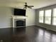 Living room featuring fireplace, ceiling fan, and large windows at 11727 Wedgeport Ln, Fishers, IN 46037
