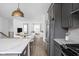View of the modern kitchen with gray cabinetry, stainless steel appliances, and a view into the living room at 1216 N Alabama St, Indianapolis, IN 46202