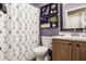 Well-organized bathroom features vanity with a dark wood cabinet, decorative shelves and a patterned shower curtain at 12328 Slate Dr, Fishers, IN 46037