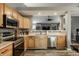 Kitchen featuring stainless appliances, light wood cabinets, and an opening to the living area at 12328 Slate Dr, Fishers, IN 46037