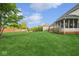 Beautifully maintained green backyard featuring mature trees, a brick fence, play set and a screened in porch at 13868 Broad Mdw, Carmel, IN 46032