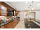 Finished basement wet bar featuring dark wood cabinetry, black granite countertops, and pendant lighting at 13868 Broad Mdw, Carmel, IN 46032