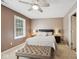 Neutral bedroom featuring a ceiling fan, a tufted ottoman, and a comfortable queen-size bed with side tables at 13868 Broad Mdw, Carmel, IN 46032