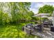 Inviting backyard patio featuring comfortable seating, umbrellas, and a grill, perfect for outdoor entertaining and relaxation at 14291 Holly Berry Cir, Fishers, IN 46038