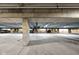 The parking garage has concrete pillars, overhead pipes and drainage in the center at 1446 N Illinois St, Indianapolis, IN 46202