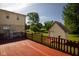 Side view of spacious wooden deck features red railing, partial home and outbuilding at 16226 Montrose Ln, Westfield, IN 46074