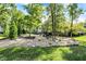 Lush backyard features a rock garden, decorative stones, and mature shade trees, perfect for entertaining at 16890 Catkins Ct, Westfield, IN 46074