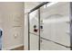Modern shower with glass doors and built-in shelving, complemented by neutral wall art and tile flooring at 16890 Catkins Ct, Westfield, IN 46074