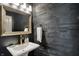 Stylish powder room featuring a modern sink, gold fixtures, and a wood plank accent wall at 16890 Catkins Ct, Westfield, IN 46074