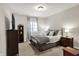 Serene bedroom features neutral tones, soft bedding, a dark dresser with television and a window that provides natural light at 16890 Catkins Ct, Westfield, IN 46074