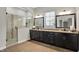 Bright main bathroom with a double vanity, a large glass shower, and wood look floors at 16890 Catkins Ct, Westfield, IN 46074