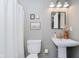 Charming bathroom showcasing a pedestal sink, a toilet, and a stylish mirror, creating a serene space at 18760 Pilot Mills Dr, Noblesville, IN 46062