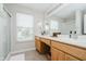 Bright bathroom with double vanity, two windows, neutral walls, a tiled floor and a glass-enclosed shower at 18760 Pilot Mills Dr, Noblesville, IN 46062