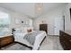 Bright bedroom featuring a neutral color palette, stylish light fixture, and wood-look floors at 18760 Pilot Mills Dr, Noblesville, IN 46062