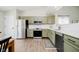 Updated kitchen with modern appliances, sage green cabinets, and white subway tile backsplash at 18760 Pilot Mills Dr, Noblesville, IN 46062