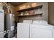 Functional laundry room with a washer, dryer, utility shelving, and a water heater at 18760 Pilot Mills Dr, Noblesville, IN 46062