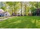 Large, green backyard featuring mature trees, offering plenty of space for recreation at 1940 Stringtown Pike, Cicero, IN 46034