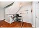 Functional office space under the stairs, featuring hardwood floors and a glass desk at 1940 Stringtown Pike, Cicero, IN 46034