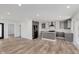 An open-concept kitchen area with grey cabinets, a central island, and modern black appliances, all in a bright, spacious setting at 2302 S Pennsylvania St, Indianapolis, IN 46225