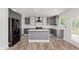 Spacious kitchen with grey cabinetry, a center island, stainless steel appliances, and light hardwood flooring at 2302 S Pennsylvania St, Indianapolis, IN 46225