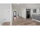 A wide-open concept design features light wood floors, white walls, a modern black door, and stainless-steel kitchen appliances at 2302 S Pennsylvania St, Indianapolis, IN 46225