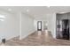 Open concept space featuring light hardwood floors, white walls, a modern black door, and a stainless steel refrigerator at 2302 S Pennsylvania St, Indianapolis, IN 46225