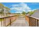 An outdoor wooden deck with an attractive railing overlooking green fields and blue skies on a sunny day at 2302 S Pennsylvania St, Indianapolis, IN 46225