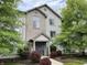 Two-story condo with a blue front door, brick and grey siding surrounded by trees and landscaping at 240 Legends Creek Pl # Apt 310, Indianapolis, IN 46229