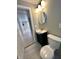 Cozy bathroom featuring a modern vanity, round mirror, and tile flooring at 2417 Crystal St, Anderson, IN 46012