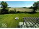 Aerial view of the backyard featuring the patio, fire pit, and the expansive green space surrounding the property at 2780 Cormorant Dr, Greenwood, IN 46143