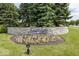 Stone community entrance sign surrounded by flowers, greenery, and manicured landscaping to welcome residents and visitors at 2780 Cormorant Dr, Greenwood, IN 46143