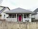 Charming home featuring a stone facade, inviting front porch with white railings and a vibrant red front door at 309 N Forest Ave, Indianapolis, IN 46201